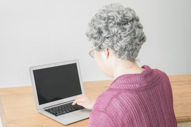 パソコンを触る年配女性